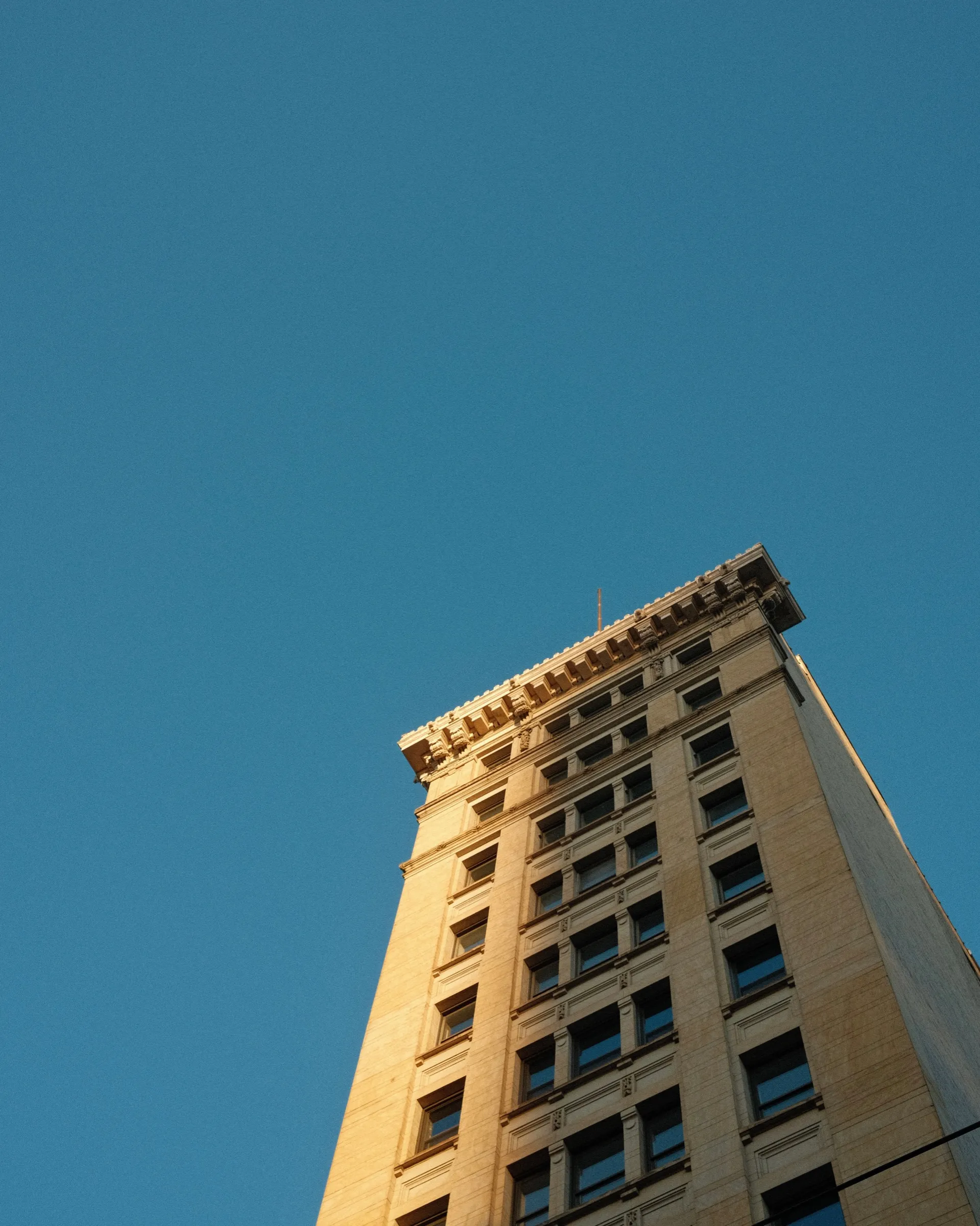 Tall stone tower against a deep blue sky at golden hour