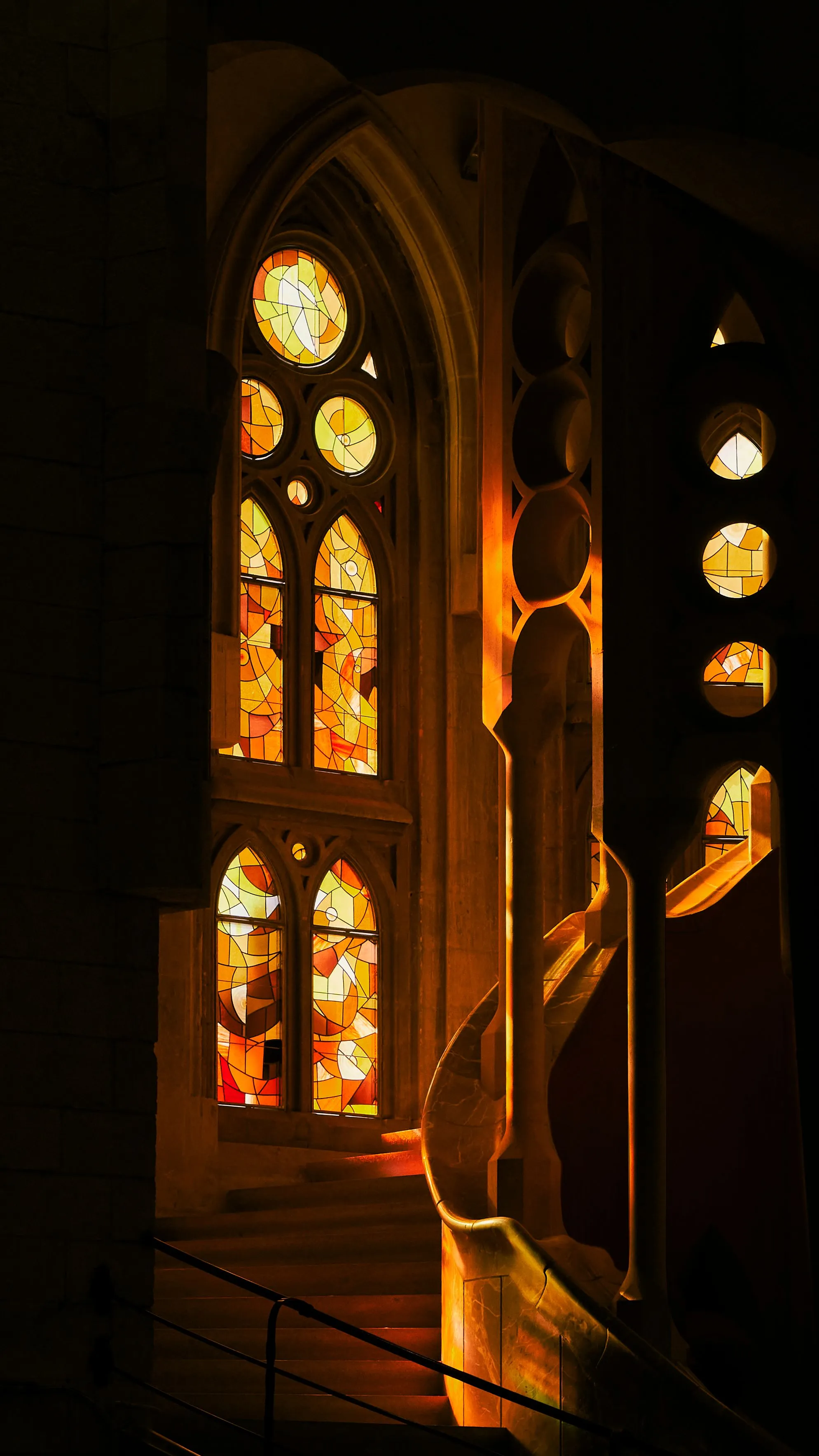 Sagrada Familia interior with glowing amber stained glass and stone columns, Barcelona